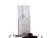 Wildflower Coffee Company presents their Rainforest Espresso Blend in a white bag with a scoop and scattered beans.
