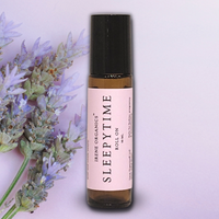 Irene Organics' Sleepytime aromatherapy roll-on is displayed next to a sprig of fresh lavender.
