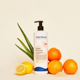 Mini Bloom Knots Be Gone hair detangling treatment sits alongside aloe, lemons, and oranges, highlighting natural ingredients.
