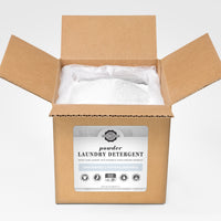 Open box reveals a bag filled with Rustic Strength unscented, hypoallergenic powder laundry detergent, detoxing laundry with earth-derived minerals.
