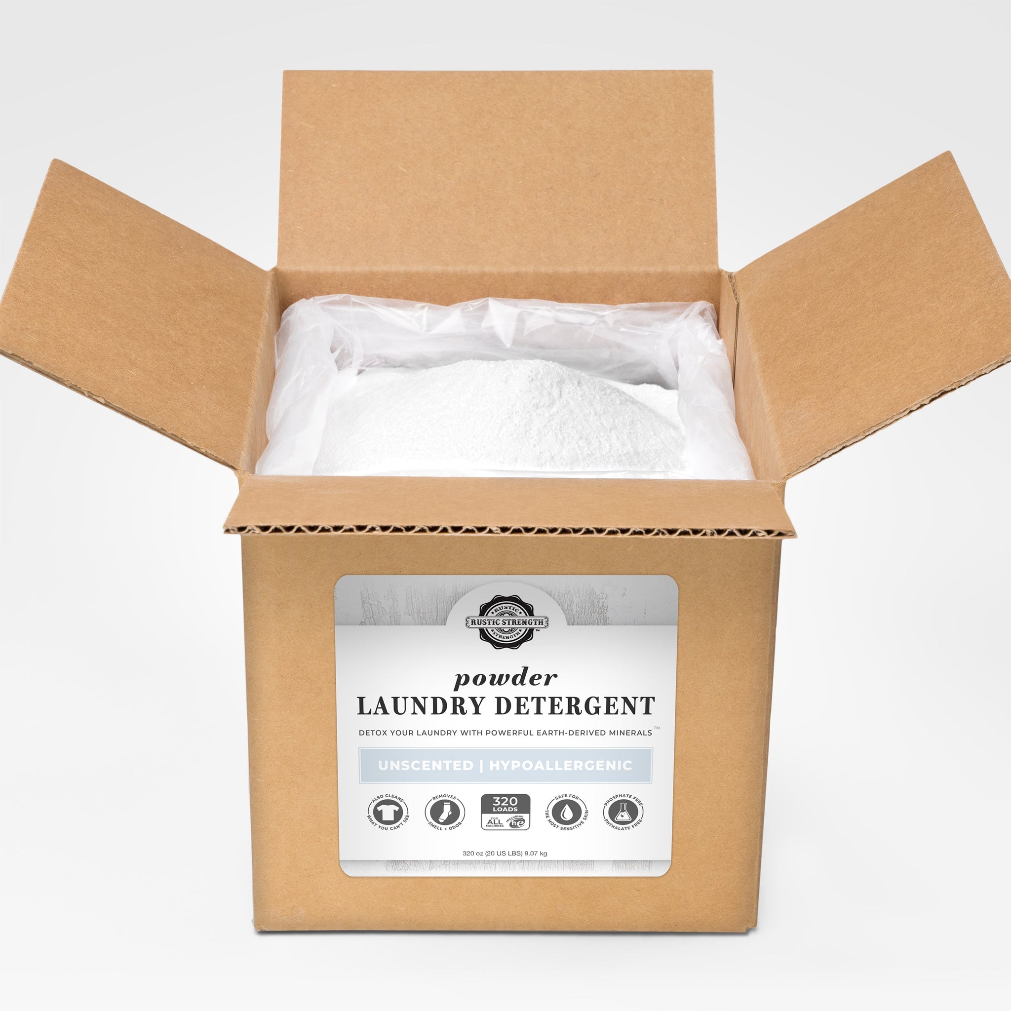 Open box reveals a bag filled with Rustic Strength unscented, hypoallergenic powder laundry detergent, detoxing laundry with earth-derived minerals.