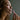 Woman smelling a pink aromatherapy inhaler against a neutral background