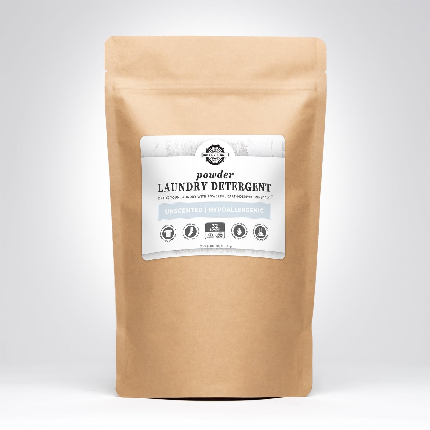 A kraft paper bag presents Rustic Strength powder laundry detergent, advertising unscented, hypoallergenic, and earth-derived minerals.
