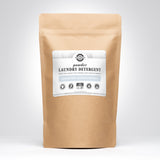 A kraft paper bag presents Rustic Strength powder laundry detergent, advertising unscented, hypoallergenic, and earth-derived minerals.
