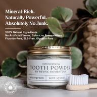 Revive Homestead presents its remineralizing tooth powder in a glass jar alongside a bamboo toothbrush.
