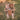 Baby in a brown baby swing outdoors on a grassy field
