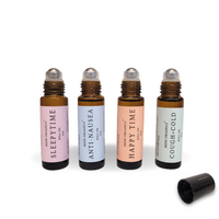 Four Irene Organics aromatherapy roll-on bottles labeled Sleepytime, Anti-Nausea, Happy Time, and Cough+Cold stand beside an open bottle cap.
