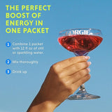A hand holds a stemmed glass filled with a bright red Gorgie energy drink against a blue sky, advertising "the perfect boost of energy in one packet" with instructions to mix with water and enjoy.
