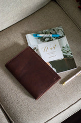 A journal, devotional book, and pen rest on a cozy, neutral-toned sofa, inviting reflection and prayer.
