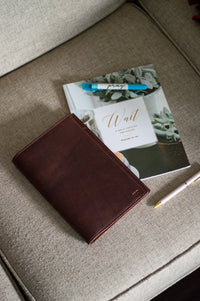 A journal, devotional book, and pen rest on a cozy, neutral-toned sofa, inviting reflection and prayer.
