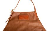 Close-up shows a stylish "Urban Southern" leather apron featuring adjustable straps and a stitched logo patch.
