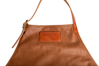 Close-up shows a stylish "Urban Southern" leather apron featuring adjustable straps and a stitched logo patch.
