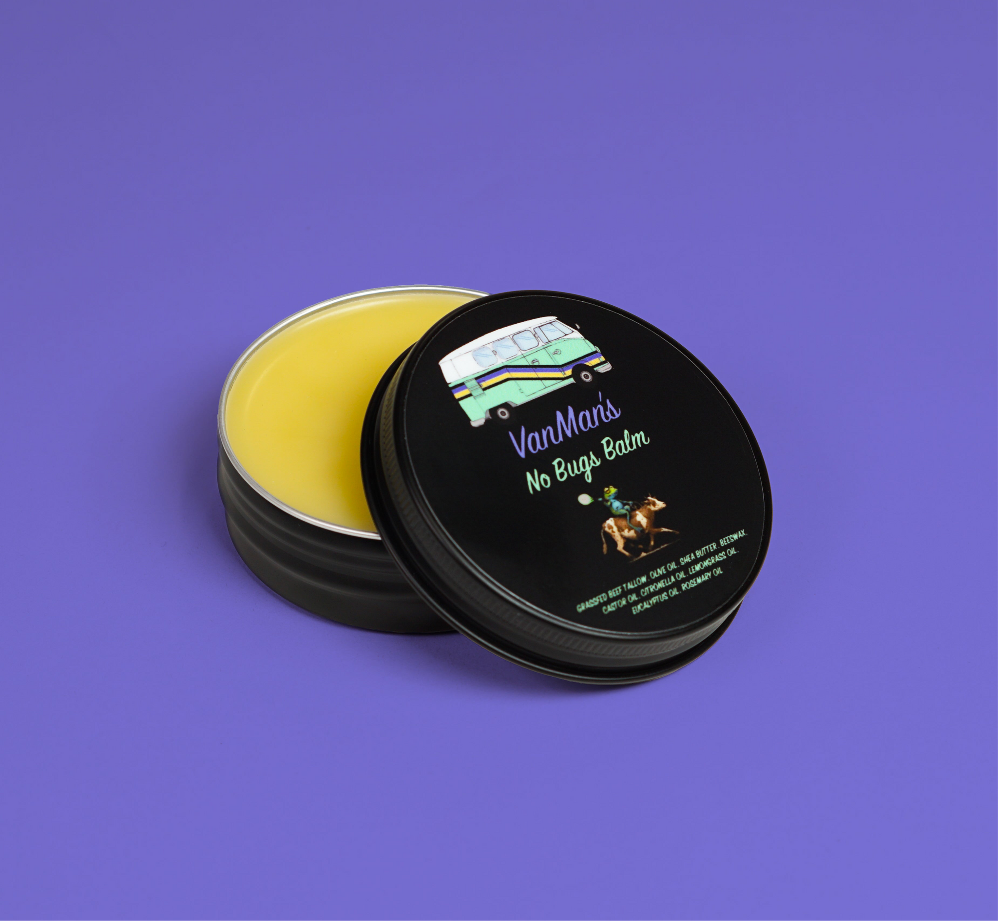 An open tin of VanMan's No Bugs Balm, featuring a VW bus and a frog riding a cow on the label, promises natural insect repellent.
