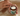 Person holding a jar of Grazly balm on a textured surface