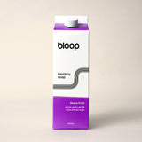 Bloop brand laundry soap, in stone fruit apricot peach plum scent, sits on a cream-colored surface.
