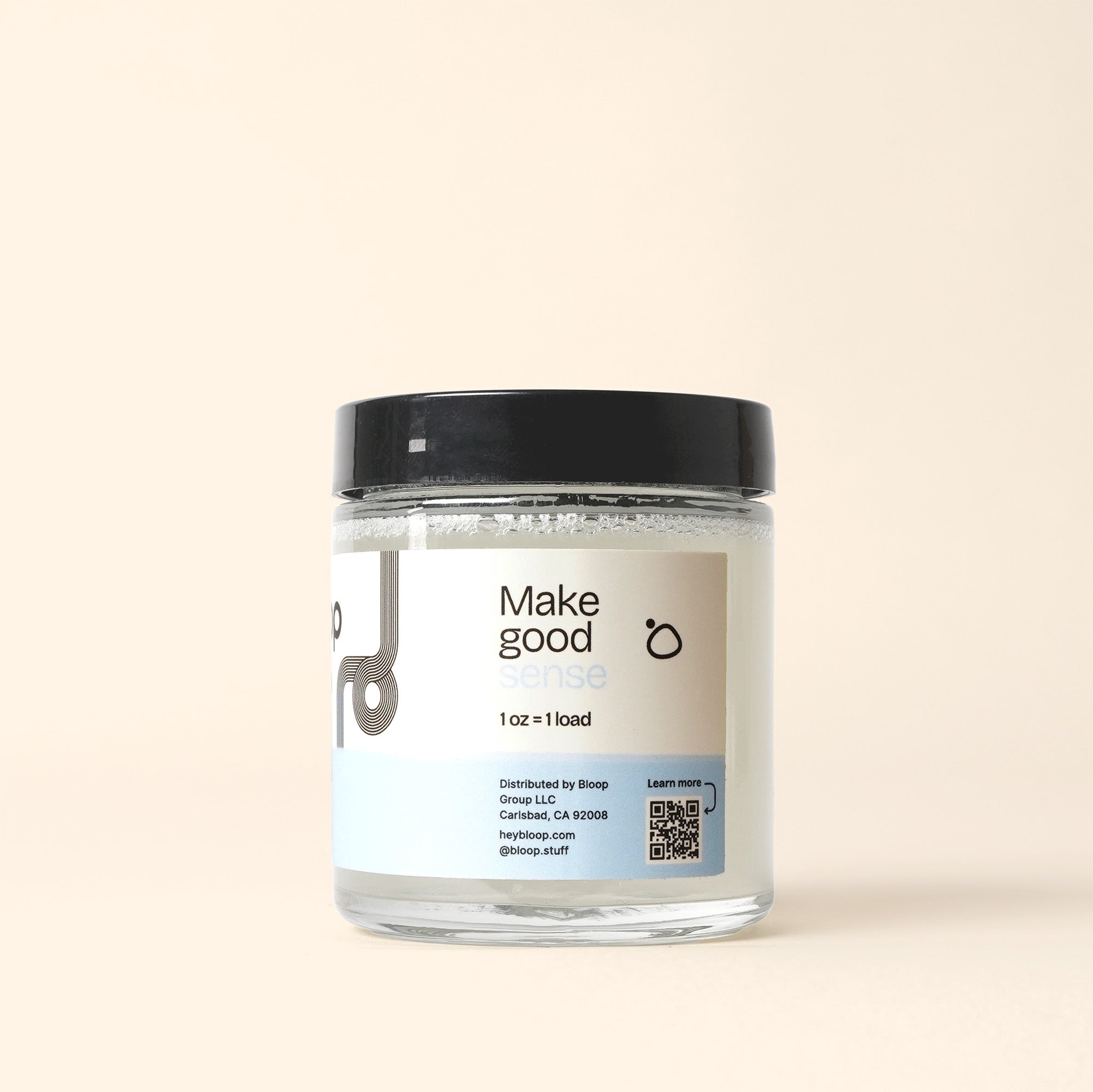 A jar of Bloop Group's "Make Good Sense" laundry detergent sits against a neutral background, promoting sustainable laundry practices.
