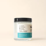 Close-up shows a jar of Bloom Laundry Soap in Salt Air scent, highlighting its eco-friendly, toxin-free ingredients.
