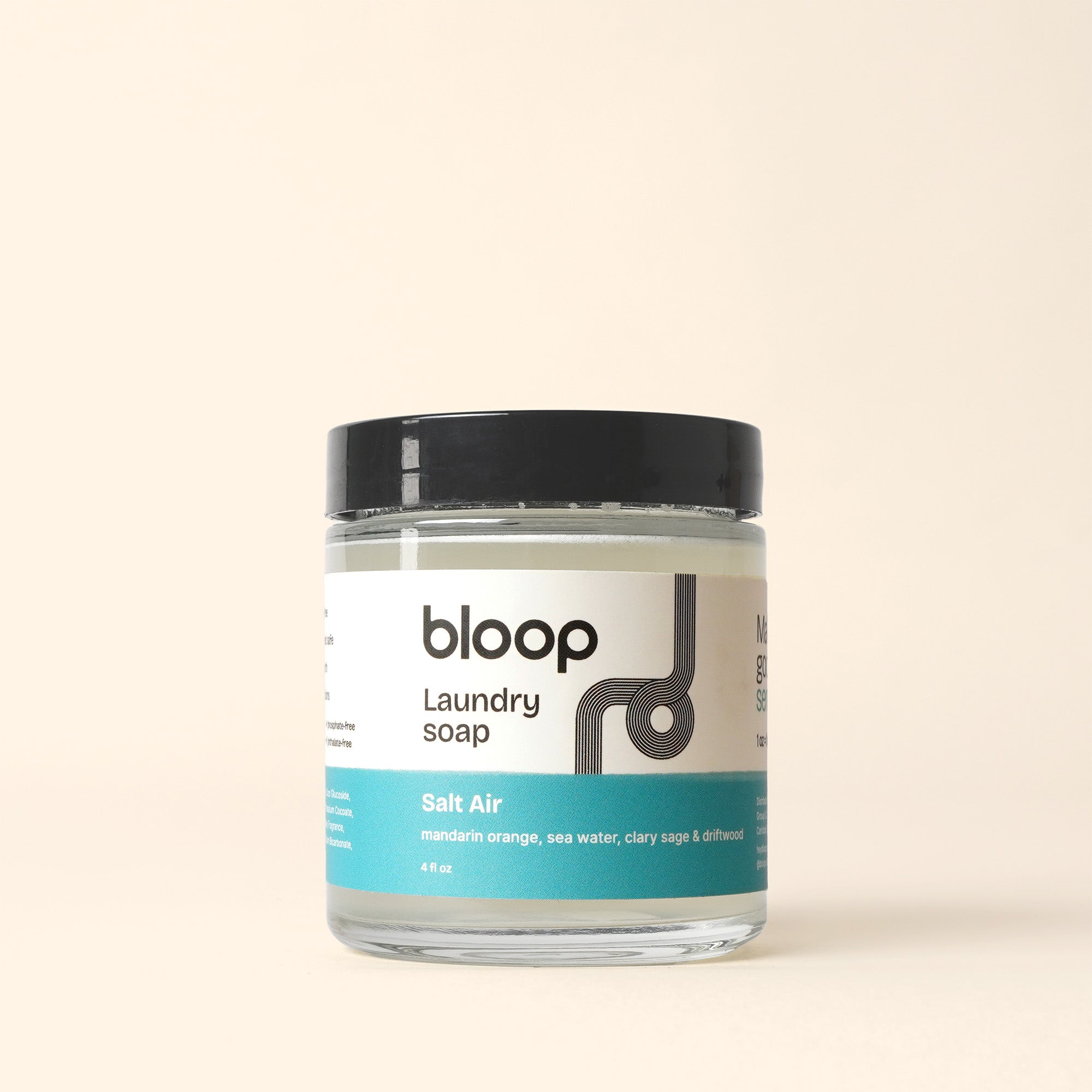 Bloop laundry soap in a glass jar with a "Salt Air" scent label, featuring mandarin orange, sea water, clary sage, and driftwood notes.