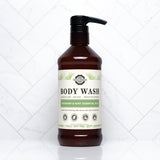 Rustic Strength's rosemary mint body wash bottle sits against a white tiled backdrop.