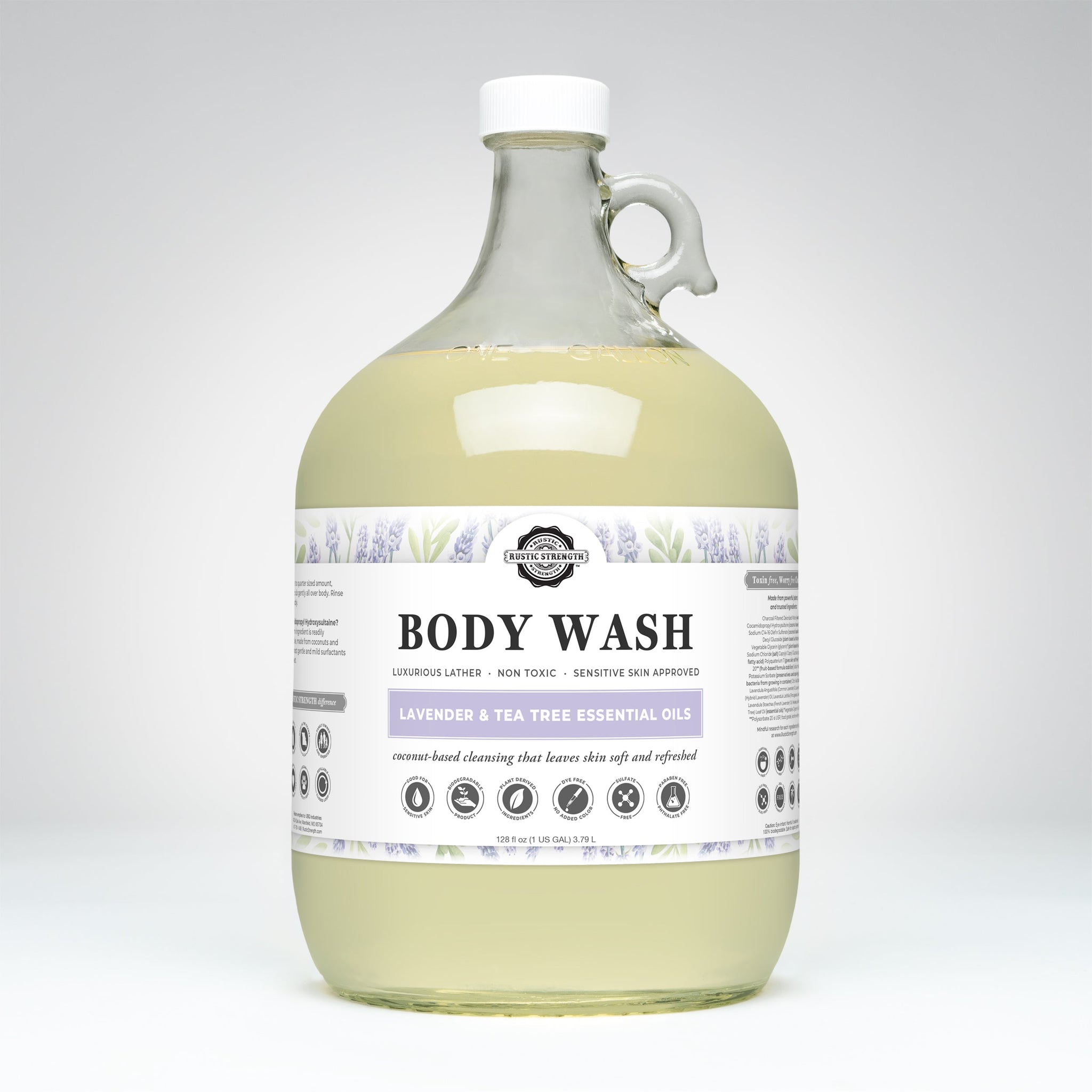 View a one-gallon glass jug of Rustic Strength body wash featuring lavender and tea tree essential oils, promising luxurious lather and gentle cleansing for sensitive skin.
