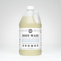 A large bottle of Rustic Strength Body Wash advertises its unscented, hypoallergenic, and coconut-based formula for sensitive skin.