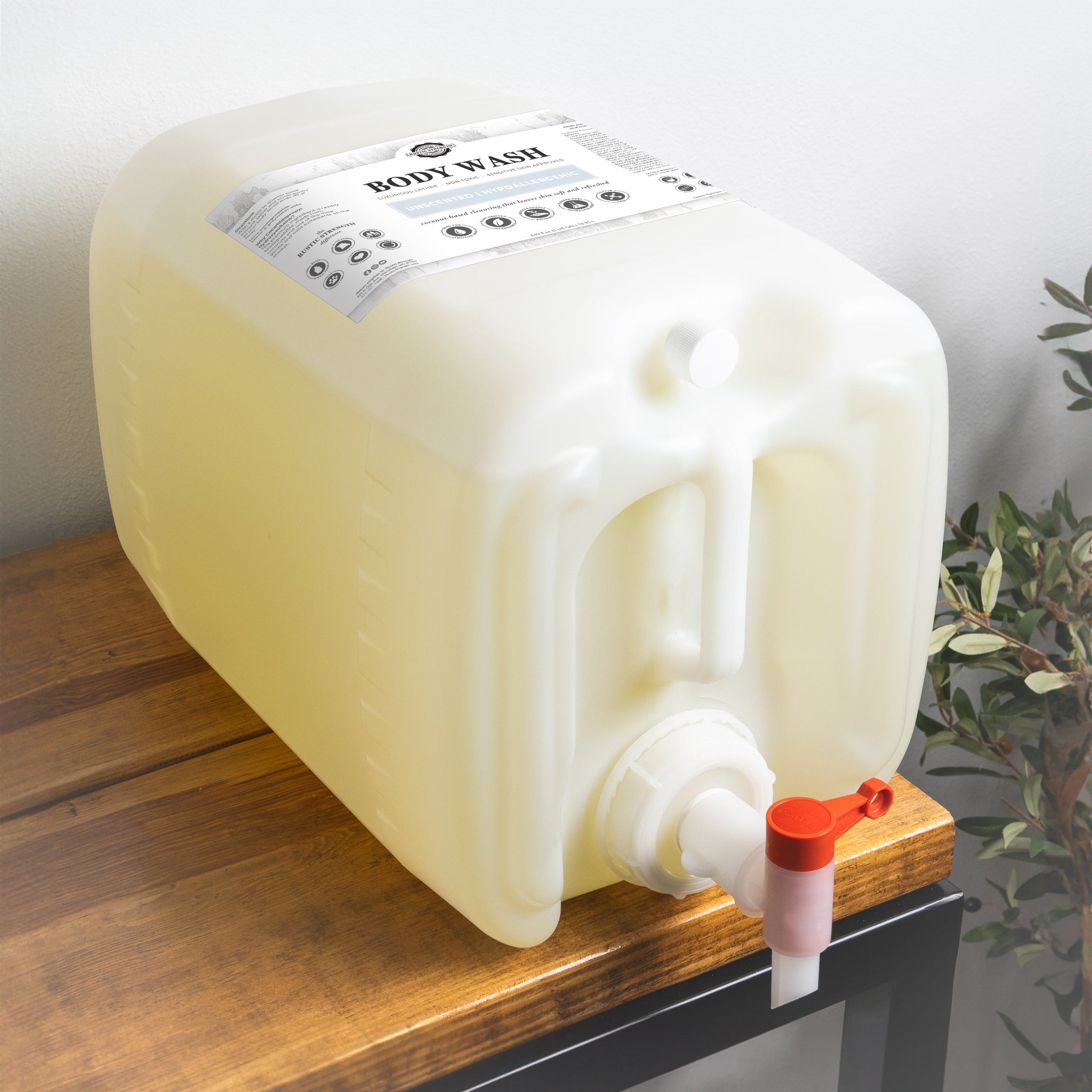 A large dispenser of unscented, hypoallergenic body wash sits on a wooden table, ready for easy dispensing.
