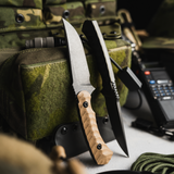 Two knives with wooden handle and metal blade on a camouflage background