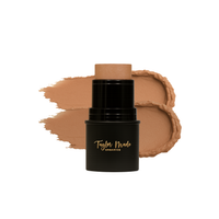 Taylor Made Organics foundation stick sits beside a creamy swatch of its tan formula.
