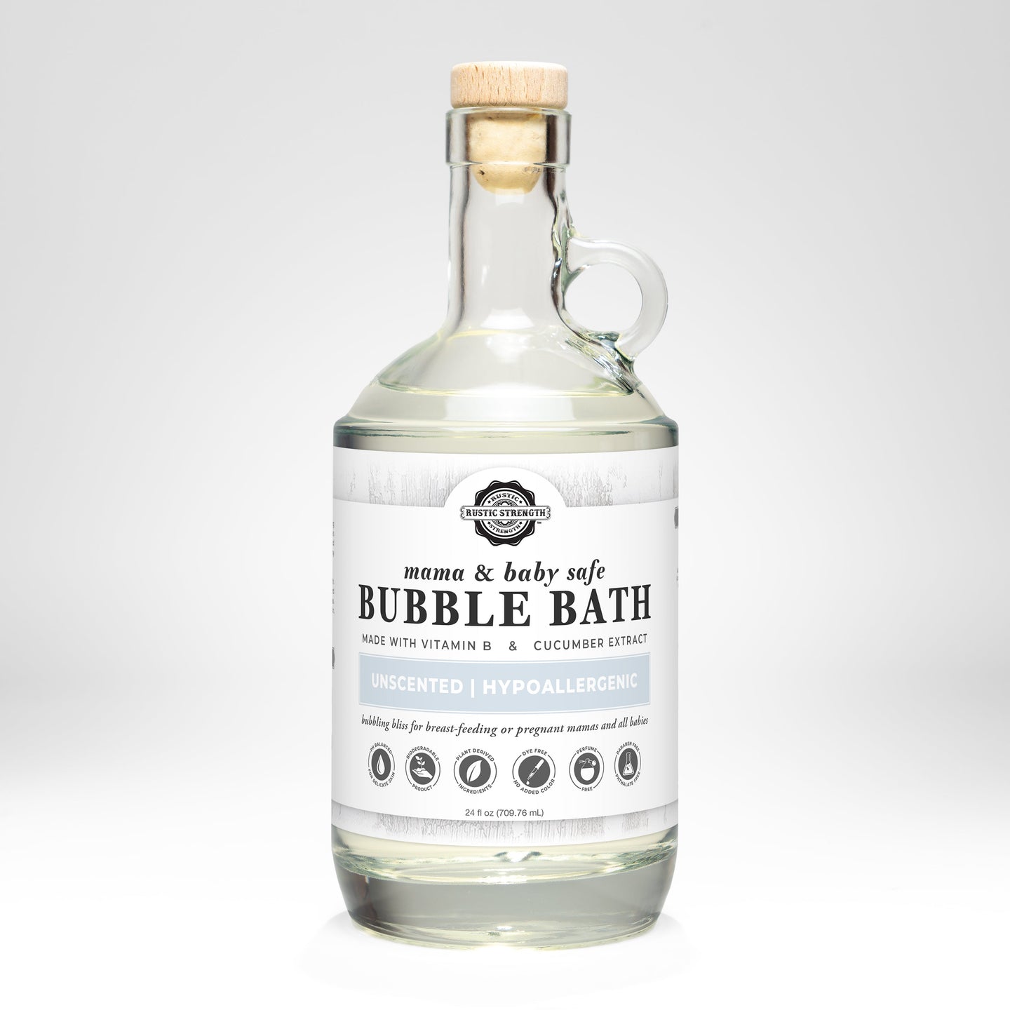 Rustic Strength presents its mama and baby safe, unscented, hypoallergenic bubble bath in a clear glass bottle with a cork stopper.
