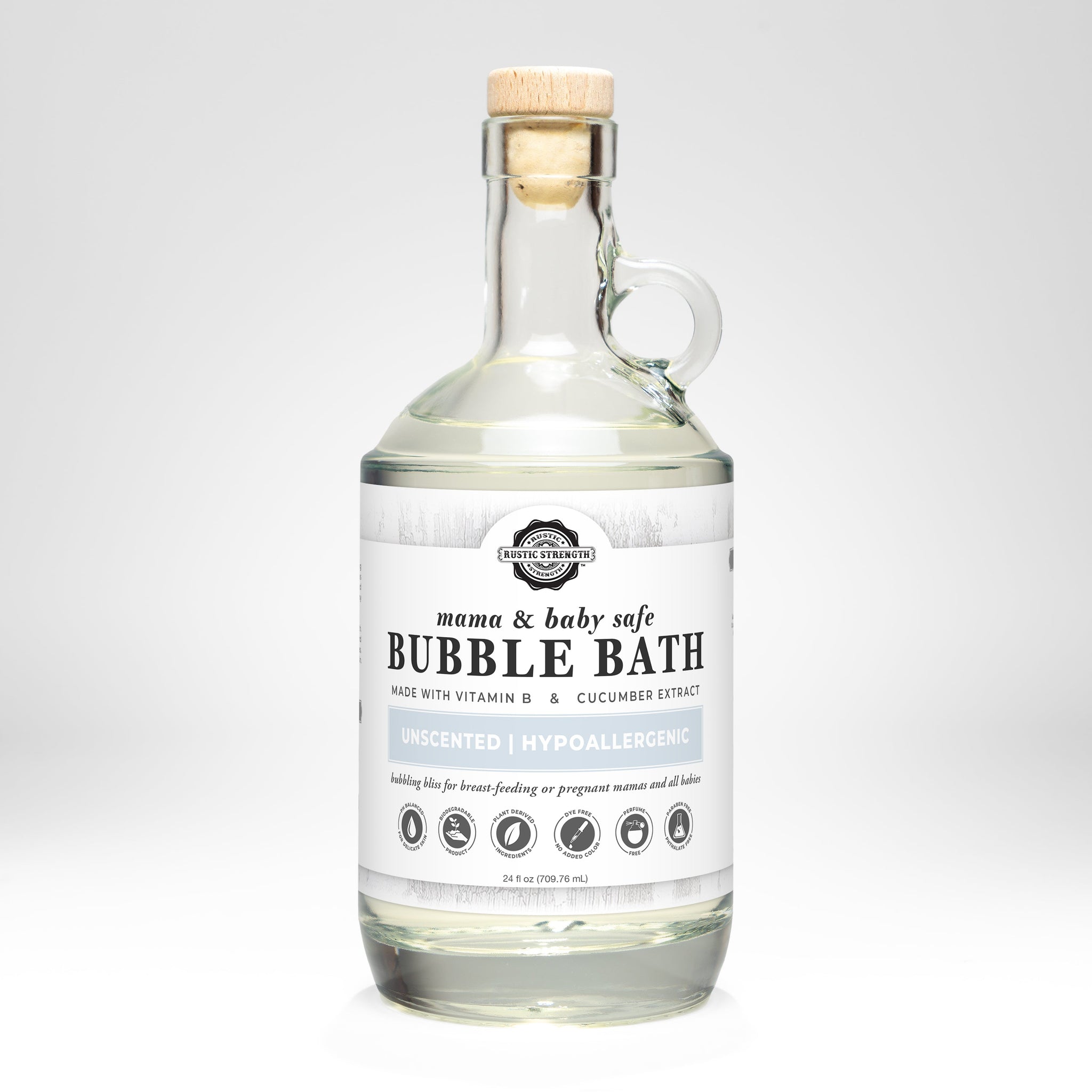 Rustic Strength presents its mama and baby safe, unscented, hypoallergenic bubble bath in a clear glass bottle with a cork stopper.
