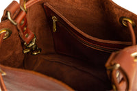 View inside a stylish brown leather bucket bag reveals a convenient zippered pocket.
