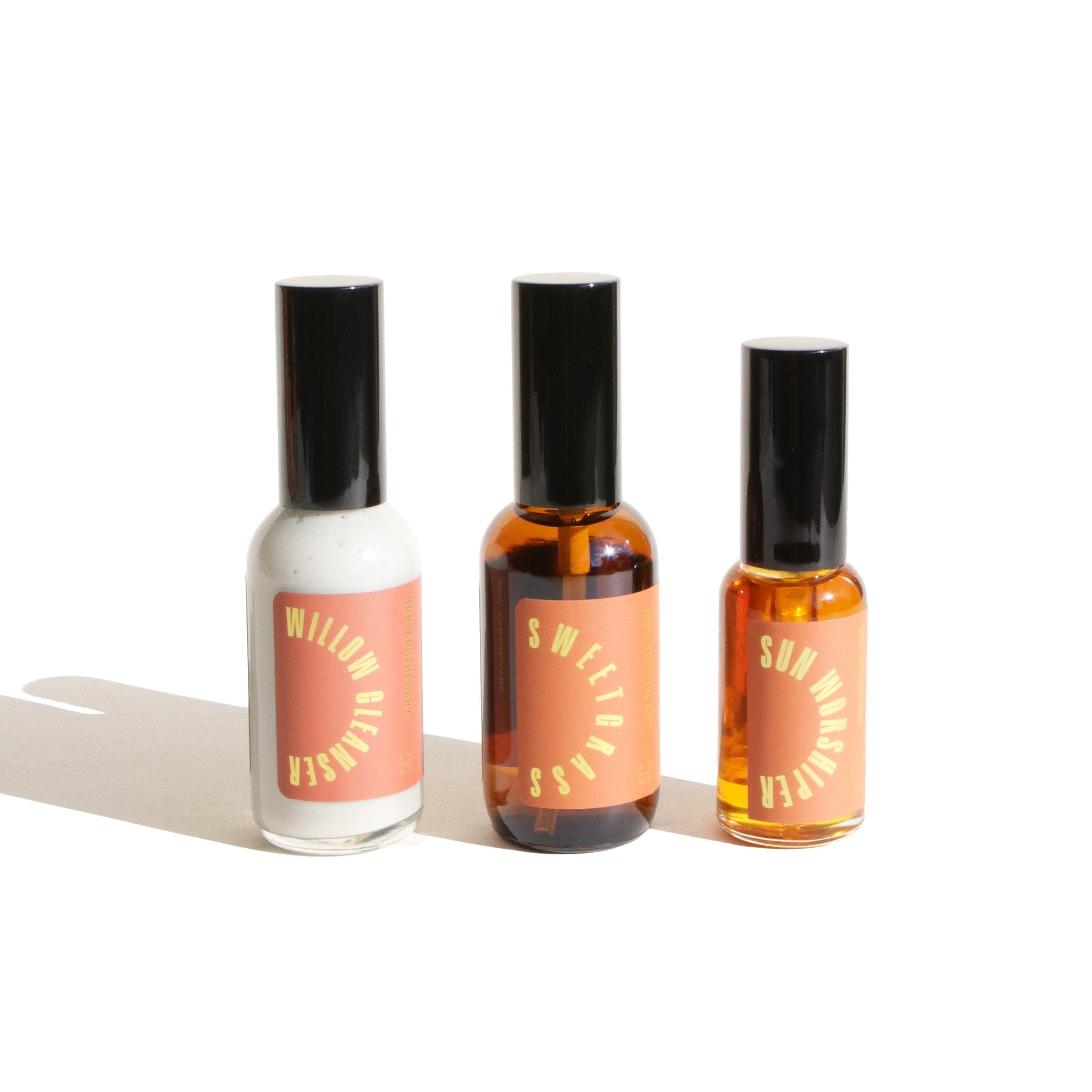 Three URB Apothecary skincare products, Willow Glonser, Sweetgrass, and Sun Worshiper, sit against a white background.

