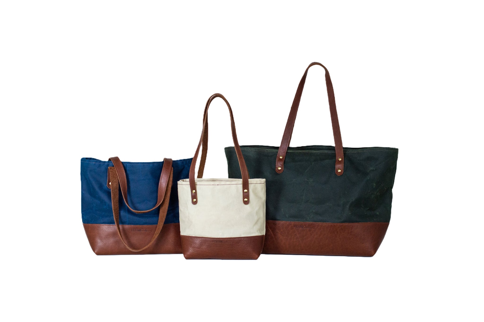 Three stylish tote bags showcase durable canvas and leather construction against a clean, white backdrop.
