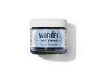 A jar of Wonder Whitening Tooth Powder sits on a white surface.
