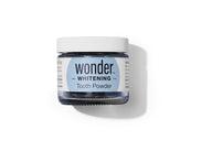 A jar of Wonder Whitening Tooth Powder sits on a white surface.
