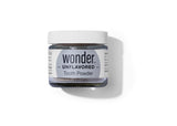 Wonder brand markets unflavorored tooth powder in a clear glass jar with a white lid.
