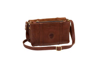 A brown leather messenger bag, showcasing the "Urban Southern" brand, sits open with a visible zipper and gold hardware.
