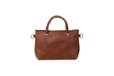 A brown leather tote bag with a zipper and round handles sits against a white background.
