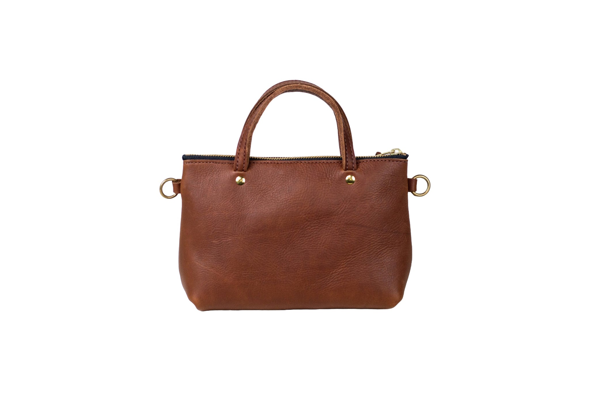 A brown leather tote bag with a zipper and round handles sits against a white background.
