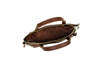 View shows the inside of a brown leather satchel handbag, its zipper open.
