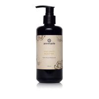 Annmarie Coconut Body Oil herb-infused moisturizer sits on a white surface.
