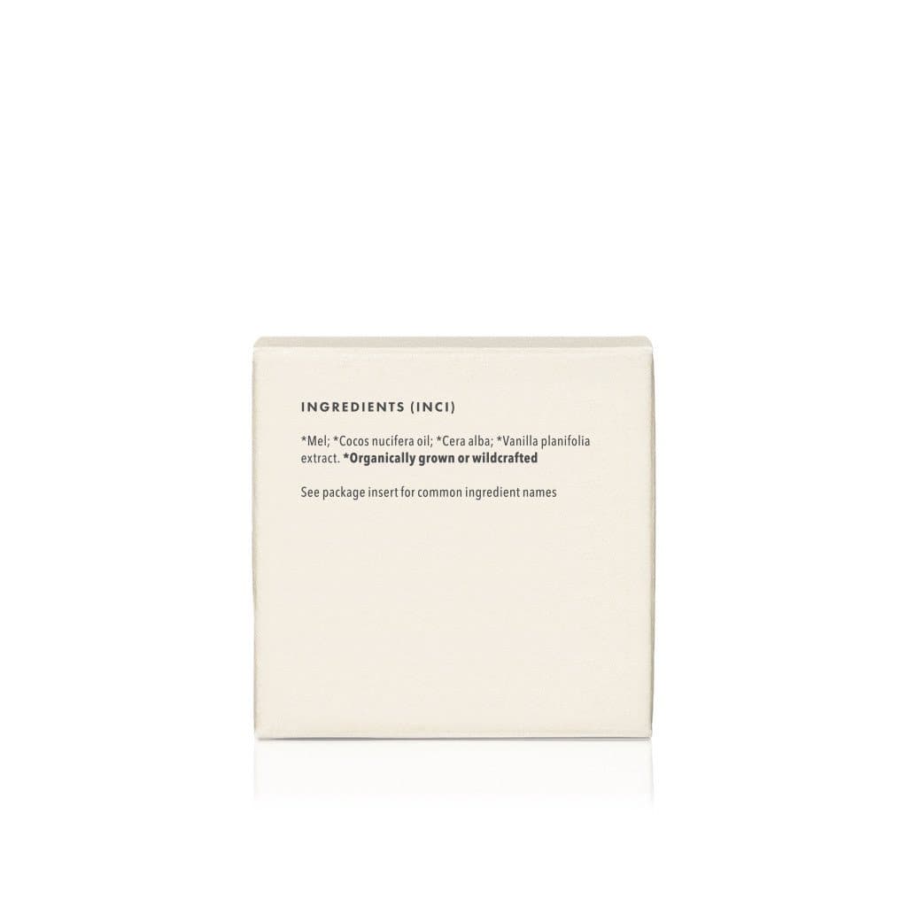 Product packaging lists the natural ingredients, including honey, coconut oil, beeswax, and vanilla extract, of this organically grown skincare product.
