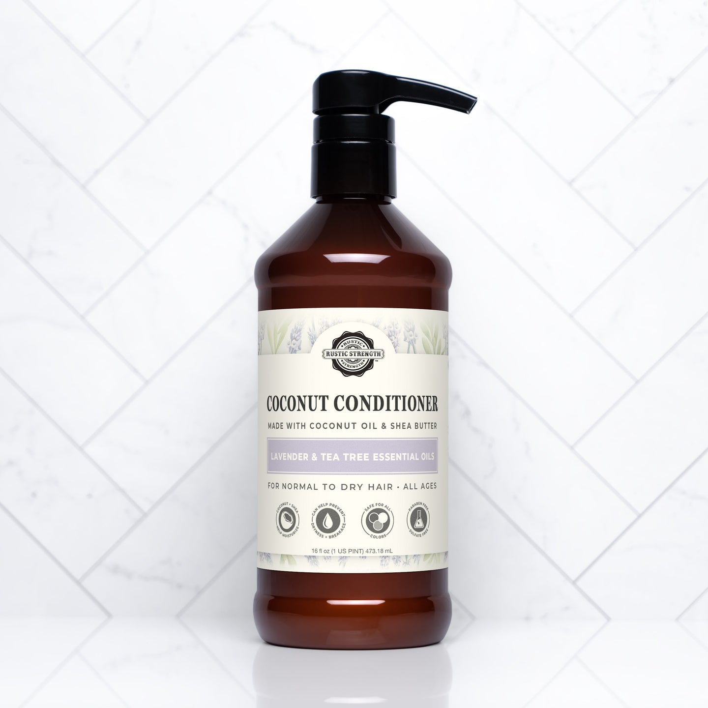 A bottle of Rustic Strength coconut conditioner with lavender and tea tree oil sits on a white marble surface.
