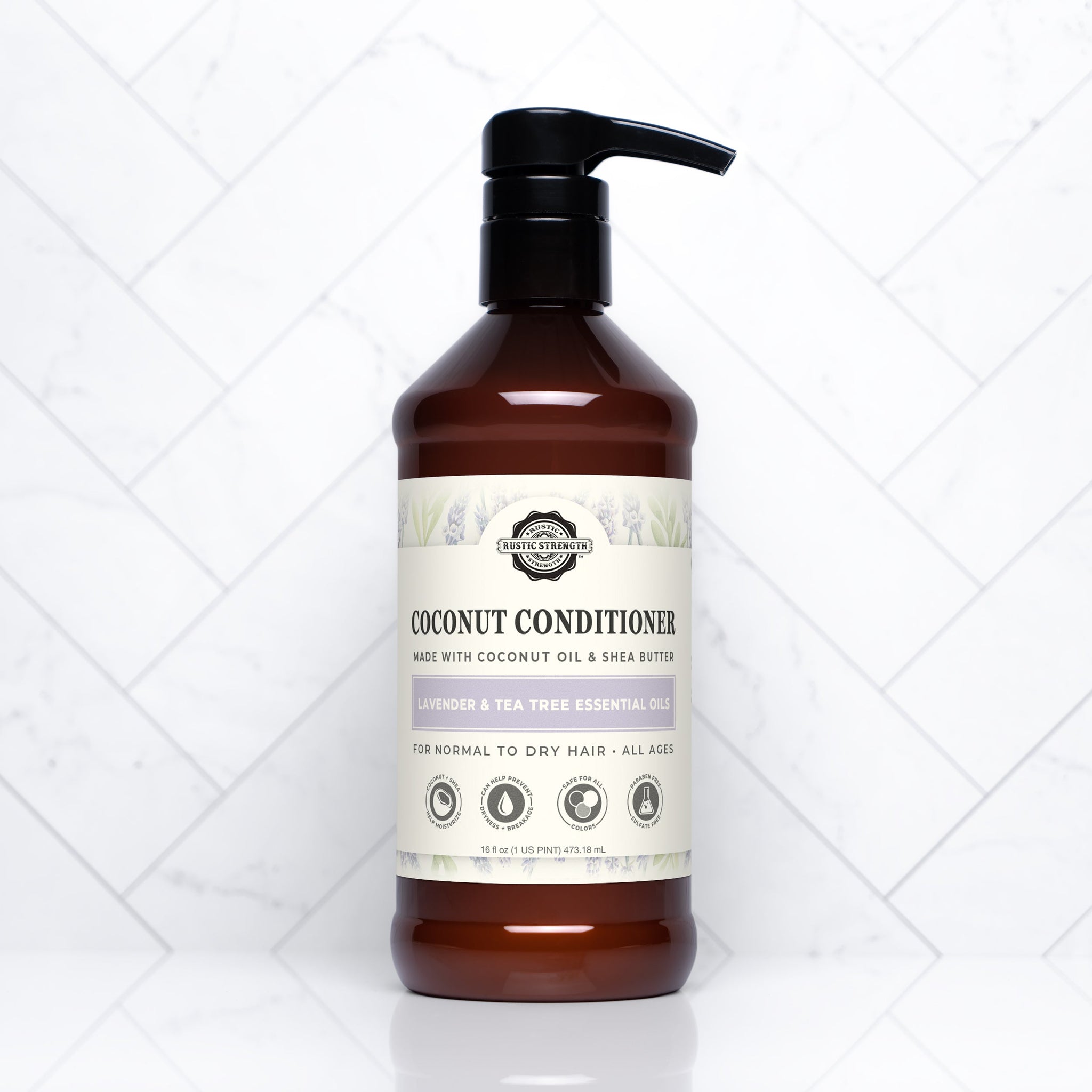 A bottle of Rustic Strength coconut conditioner with lavender and tea tree oil sits on a white marble surface.