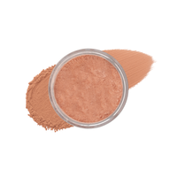 A jar of peach-toned mineral powder sits amidst a swatch of matching foundation makeup.
