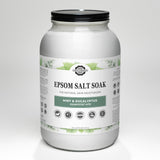 Close-up showcases a jar of Rustic Strength Epsom Salt Soak with mint and eucalyptus essential oils, emphasizing its natural skin moisturizing benefits.
