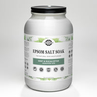 Close-up showcases a jar of Rustic Strength Epsom Salt Soak with mint and eucalyptus essential oils, emphasizing its natural skin moisturizing benefits.