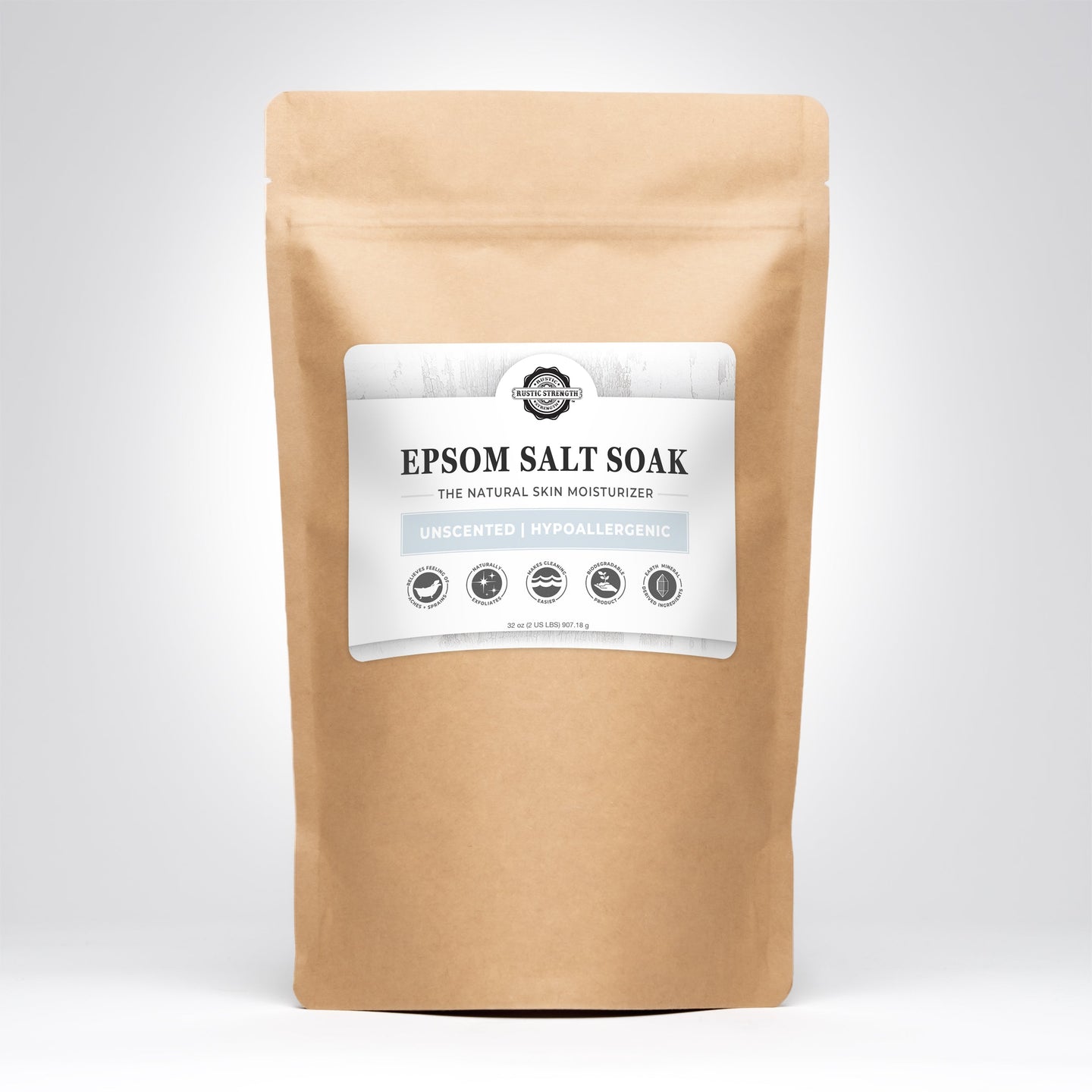 Showcases a brown paper bag containing Rustic Strength Epsom Salt Soak, a natural, unscented, hypoallergenic skin moisturizer.
