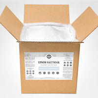 Open cardboard box reveals bulk unscented Epsom salt soak, a natural skin moisturizer, for soothing aches and exfoliating, from Rustic Strength.