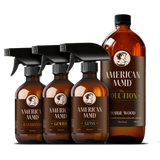 American Maid plant-based cleaning products, including bathroom cleaner, general cleaner, glass cleaner, and prairie wood scented solution, display elegantly against a black background.

